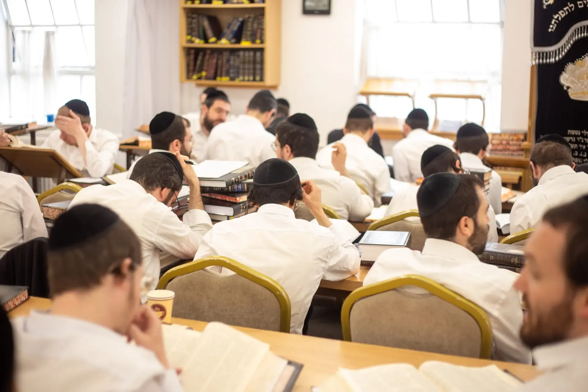 Orthodox Jewish men learning Torah together in a study hall